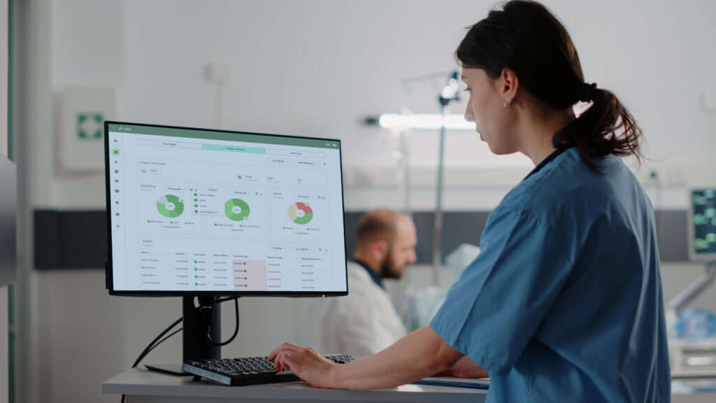 Close up of woman nurse working on computer in hospital ward