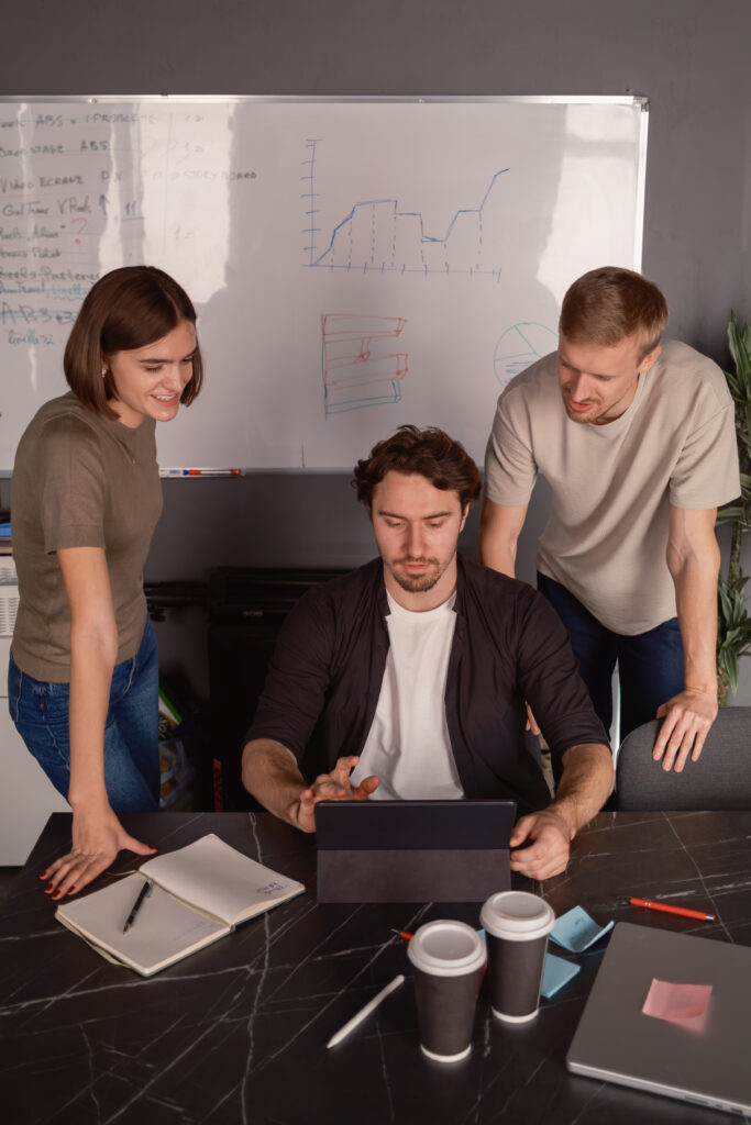 Team collaborating on a project using a tablet in a modern office setting